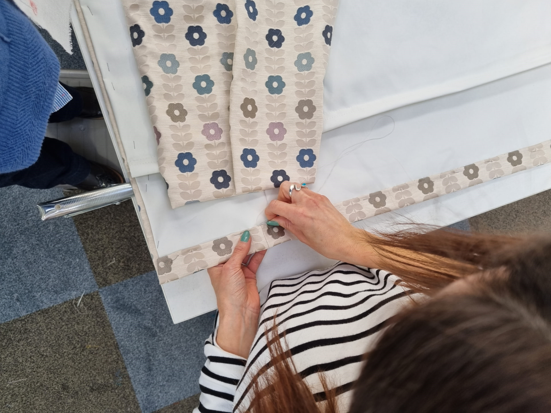 Hand-finishing a floral curtain in the Cambridge Curtains workroom